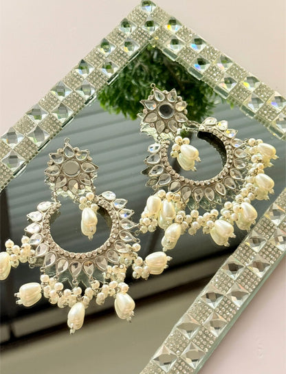 Silver Jhumka earrings by Noor E Ishq featuring intricate traditional design and hanging bell-shaped ornaments.