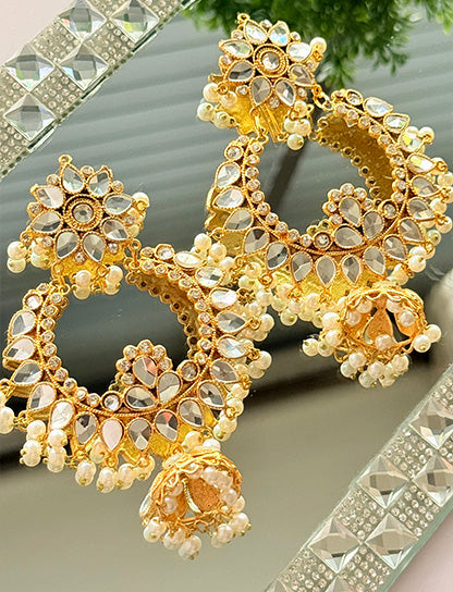 Gold jhumka earrings by Noor E Ishq featuring traditional bell-shaped design with intricate detailing.